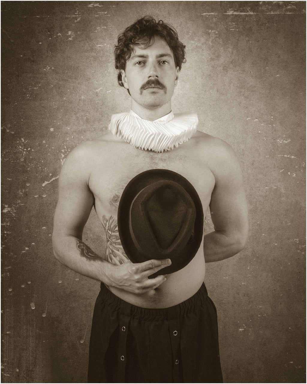Portrait sépia d’un homme moustachu, torse nu, portant une collerette blanche et tenant un chapeau sombre devant lui, sur fond vieilli. Portrait Retrouvé 1837 – III, par SchaPicShow.